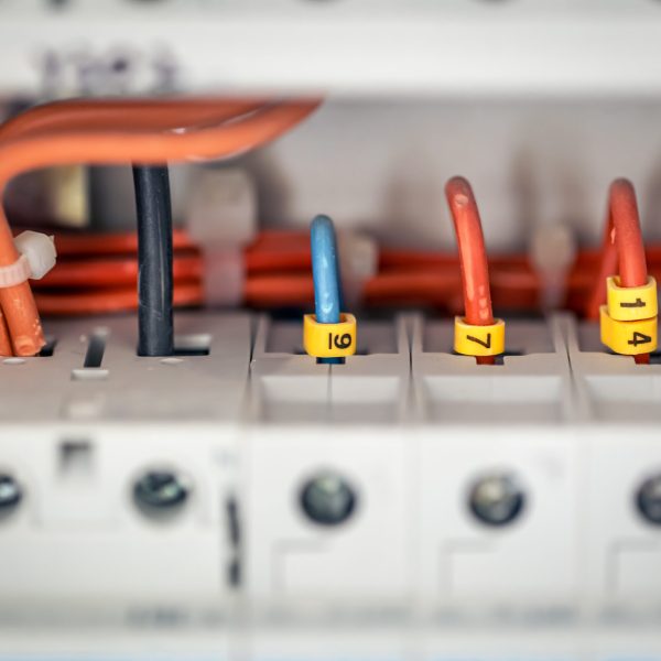 Close up circuit breakers and wire in control panel.